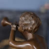 little boy playing the horn statue